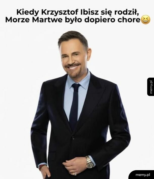 Mężczyzna w garniturze z uśmiechem na twarzy.