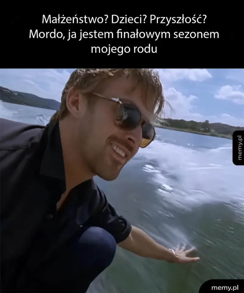 Mężczyzna w koszuli na tle wody, uśmiechnięty, wskazuje na coś.