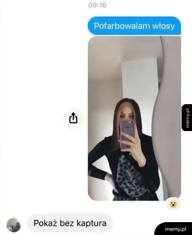 Kobieta z długimi włosami w lustrze, trzyma telefon, robiąc selfie.