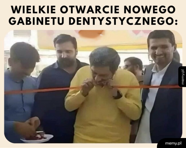 Mężczyzna przecina czerwoną wstęgę zębami podczas otwarcia.
