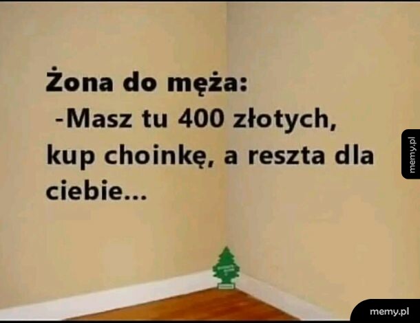 Tekst żartu na tle ściany i mała zawieszka zapachowa w rogu pokoju.