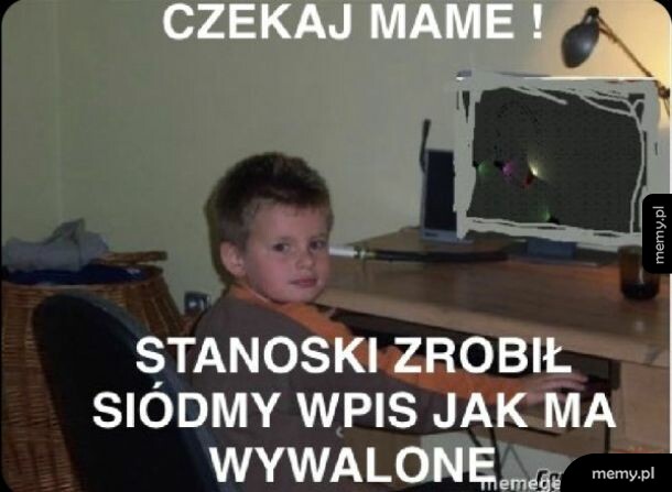 Chłopiec siedzący przed komputerem odwraca się w stronę aparatu.