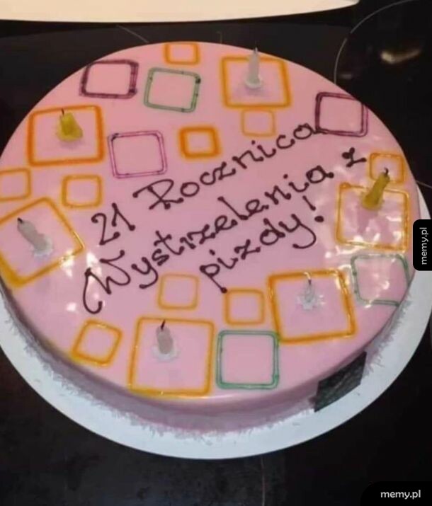 Różowy tort z kolorowymi kwadratami i świeczkami oraz napisem.
