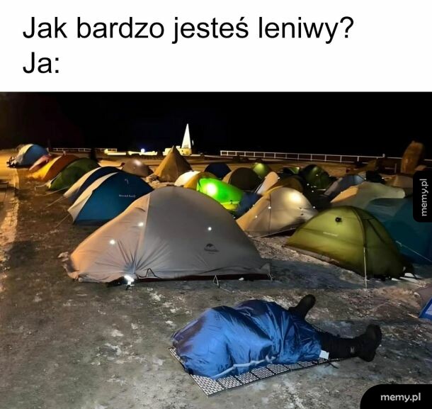 Osoba śpiąca na karimacie przed namiotami