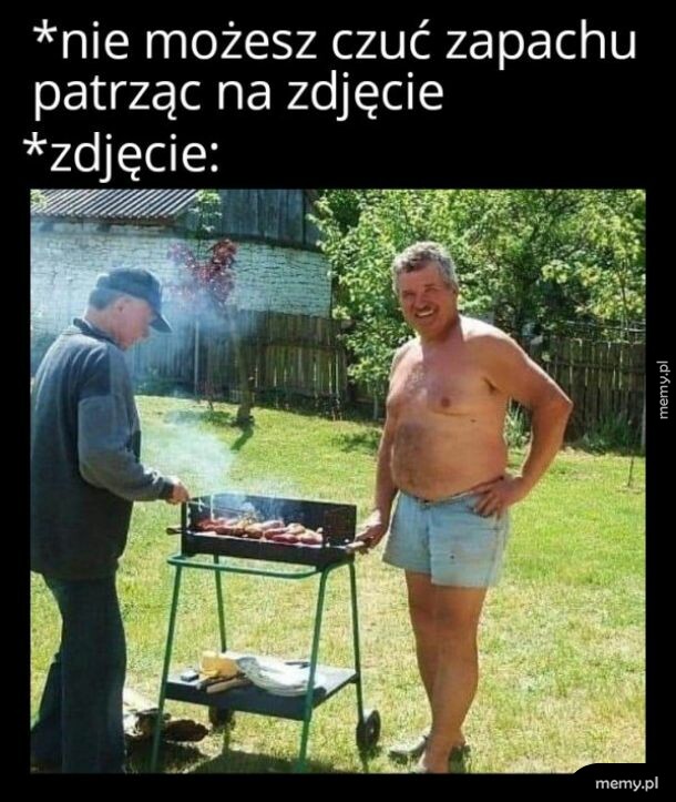 Dwóch mężczyzn przy grillu w ogrodzie, jeden bez koszulki uśmiecha się do aparatu.